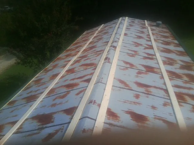 Rusted metal roof panels with new wood purlins before replacement — Storm Damage Roof Repair in South Haven by Roofing Brothers